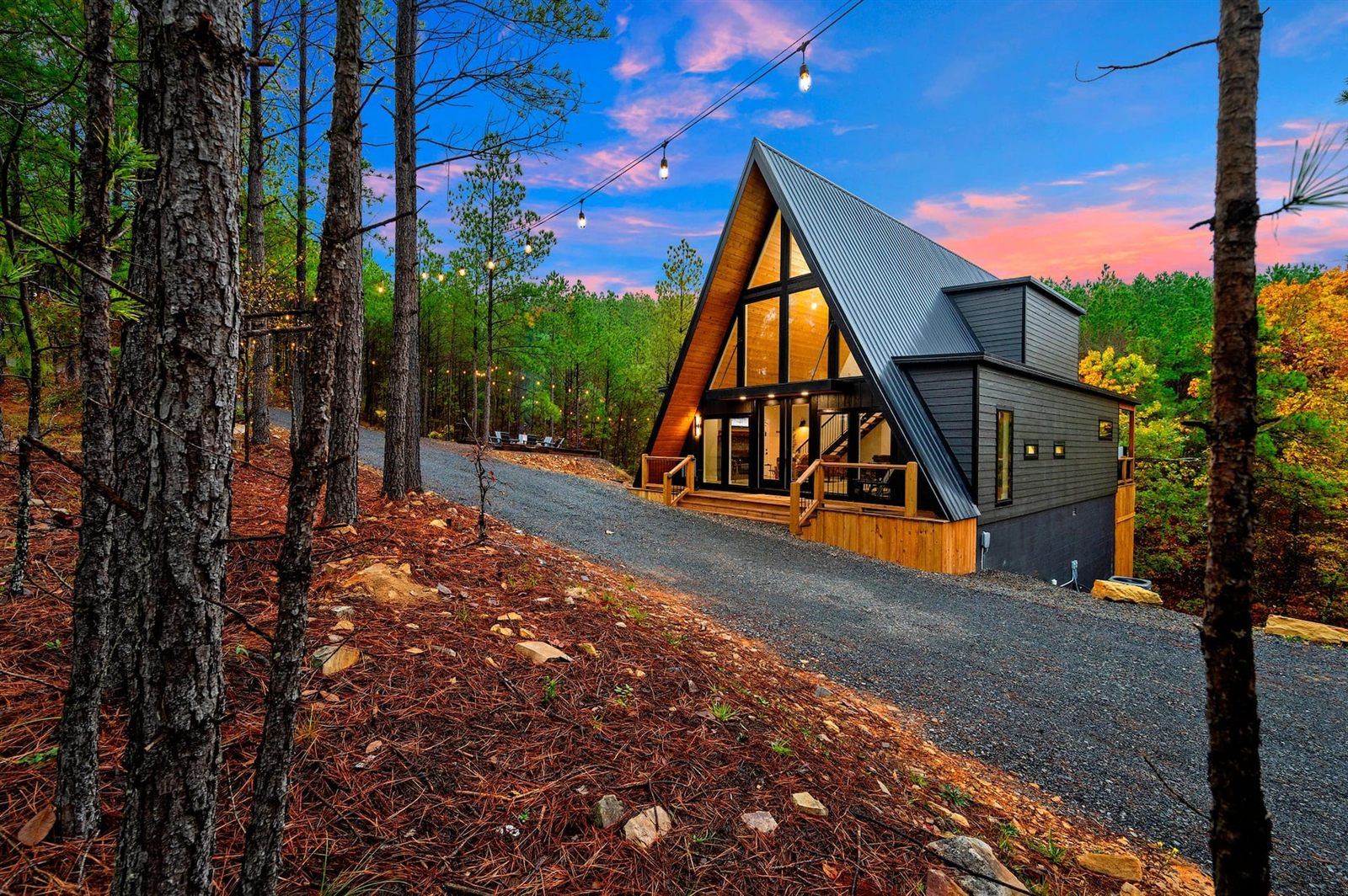 Adventus A-frame cabin at dusk, string lights on the porch